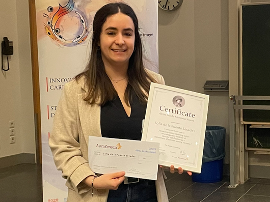 Dunkelhaarige junge Frau mit Auszeichnung in den Händen