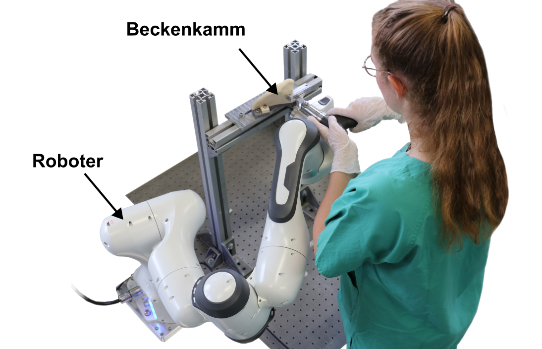 Bild einer Frau in Rückenansicht, die einen Operationsroboter bedient, der ihr bei einer Beckenkamm OP hilft.