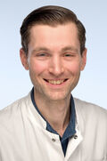 Porträtfoto eines Mannes mit braunen Haaren.